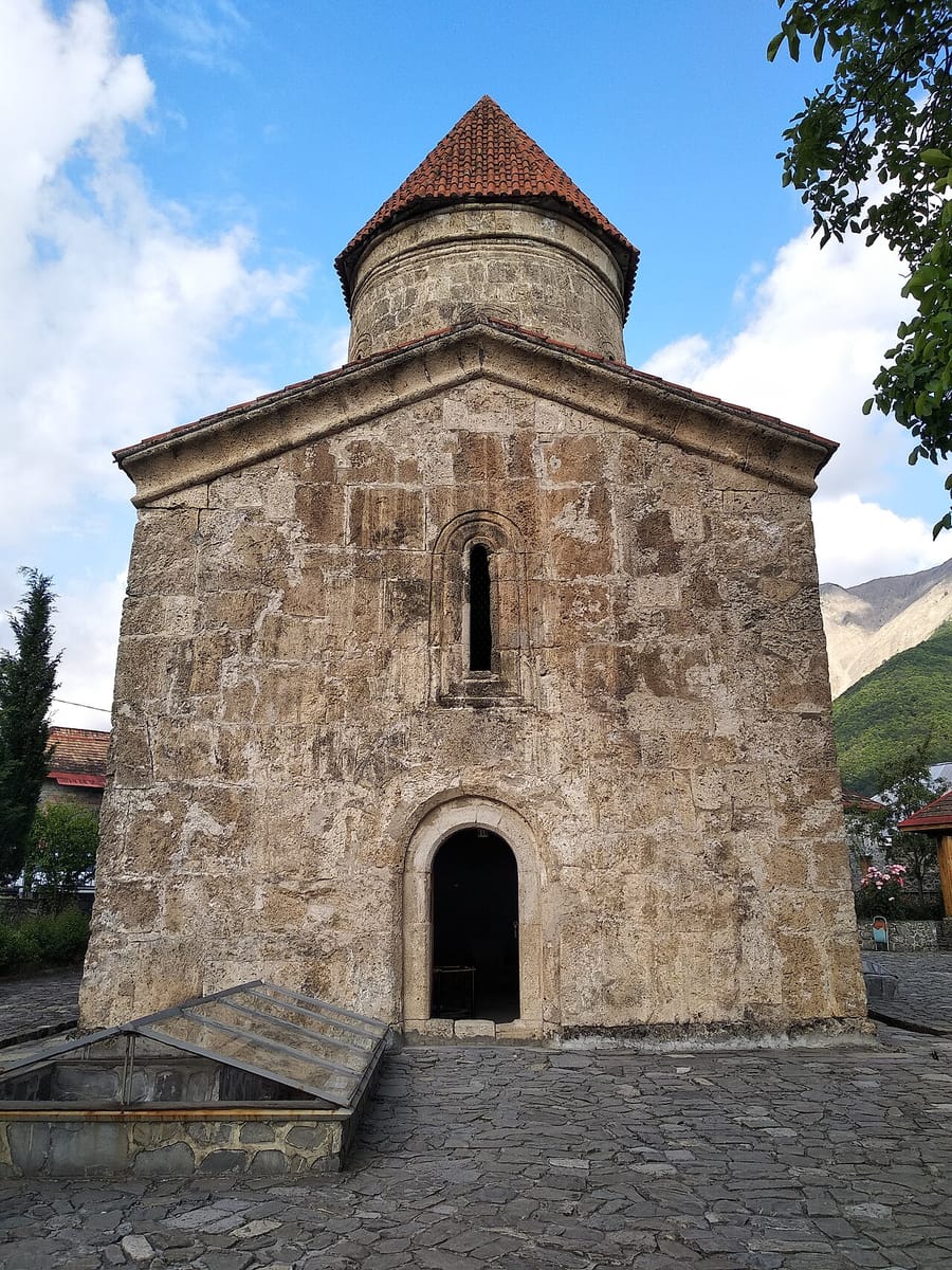 Qərb fasadı: qoşa tağlı giriş, üstündə dar pəncərə, 2018
